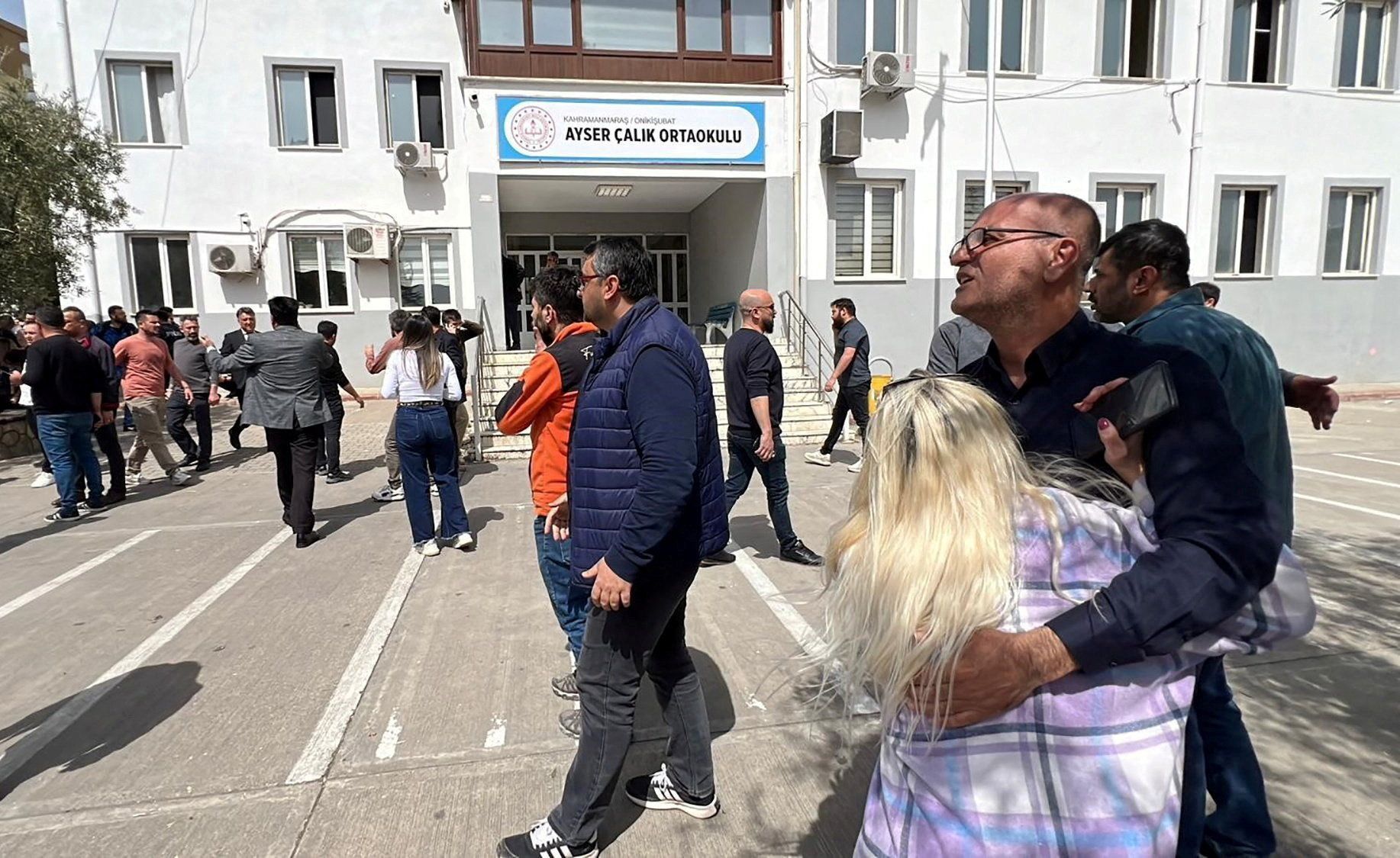 Pessoas esperam em frente ao prédio da escola após ataque no sudeste da Turquia nesta quarta-feira (15)
