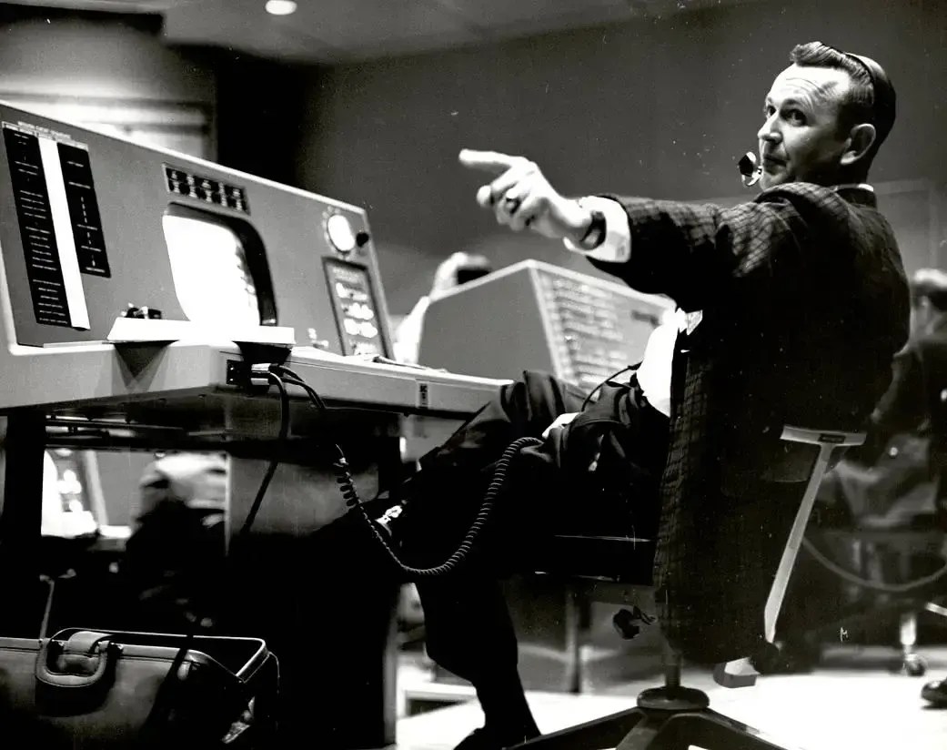 Christopher Kraft, diretor de voo durante o Projeto Mercury, trabalha em seu console dentro da área de Controle de Voo no Centro de Controle da Missão Mercury. • Nasa