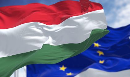 Detail of the national flag of Hungary waving in the wind with blurred european union flag in the background