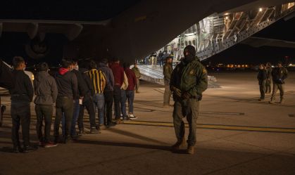Agentes da Alfândega e Proteção de Fronteiras dos EUA orientam imigrantes a embarcarem em aeronave