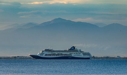 O navio de passageiros Celestyal Cruises navegando perto de Tessalônica, com o Monte Olimpo ao fundo