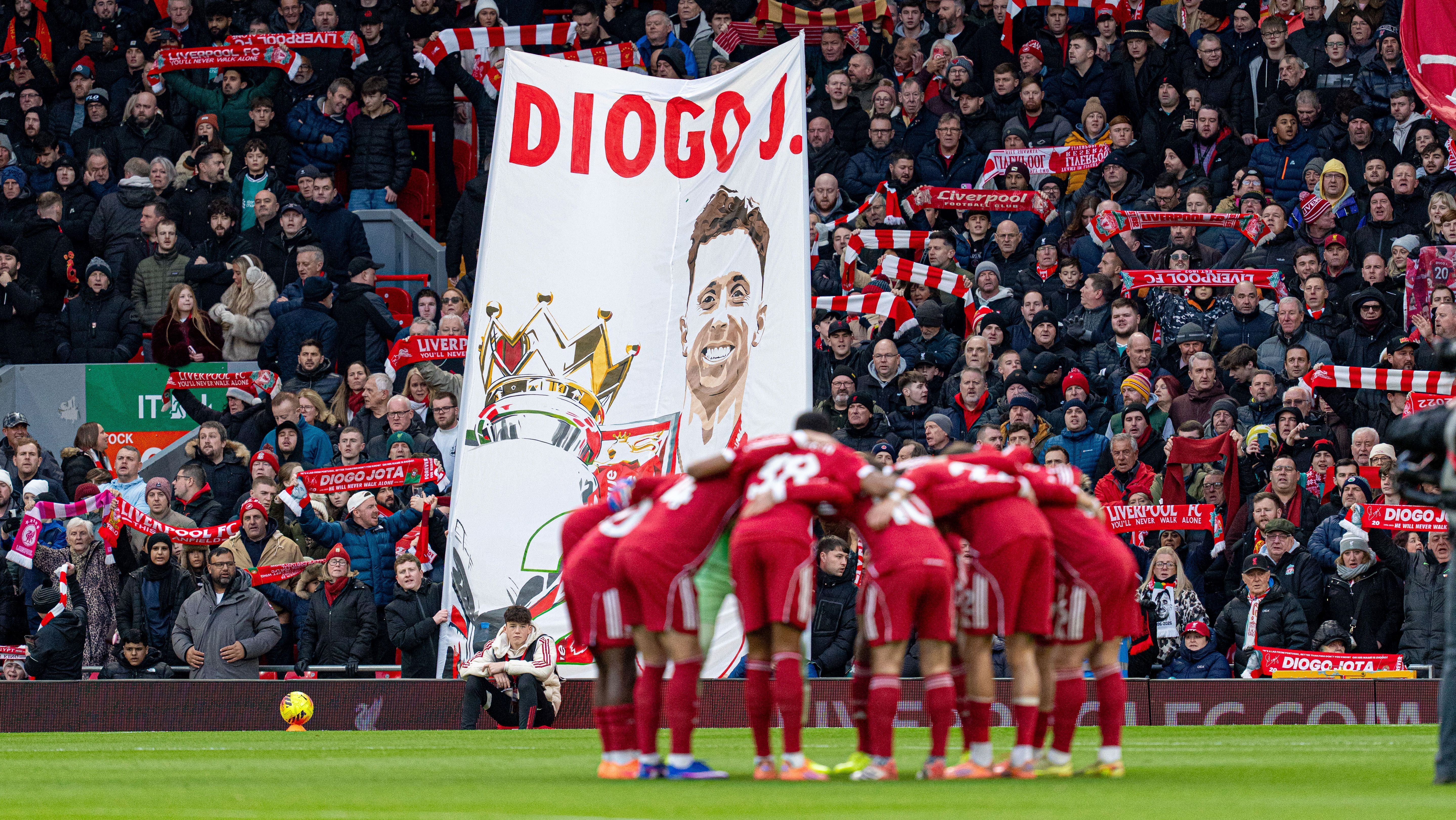 Jogadores do Liverpool se reúnem em frente a uma faixa em homenagem a Diogo Jota durante a partida da Premier League contra o Wolverhampton, em Anfield