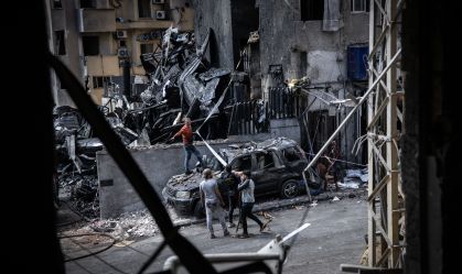 Pessoas tentam remover um veículo destruído em um ataque aéreo israelense em Beirute, no Líbano