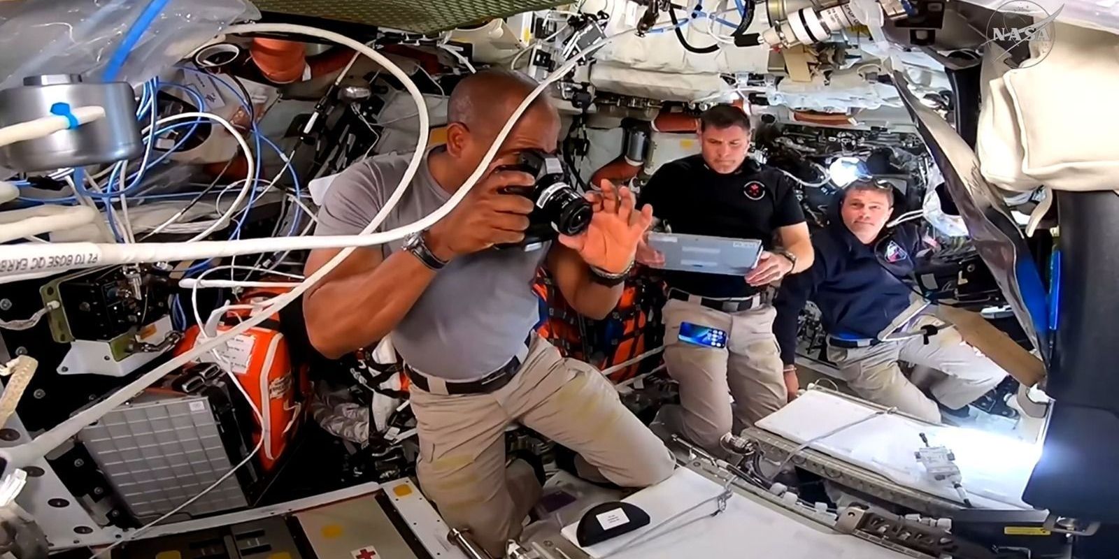 Victor Glover, Jeremy Hansen e Reid Wiseman trabalham juntos dentro da espaçonave Orion • Nasa