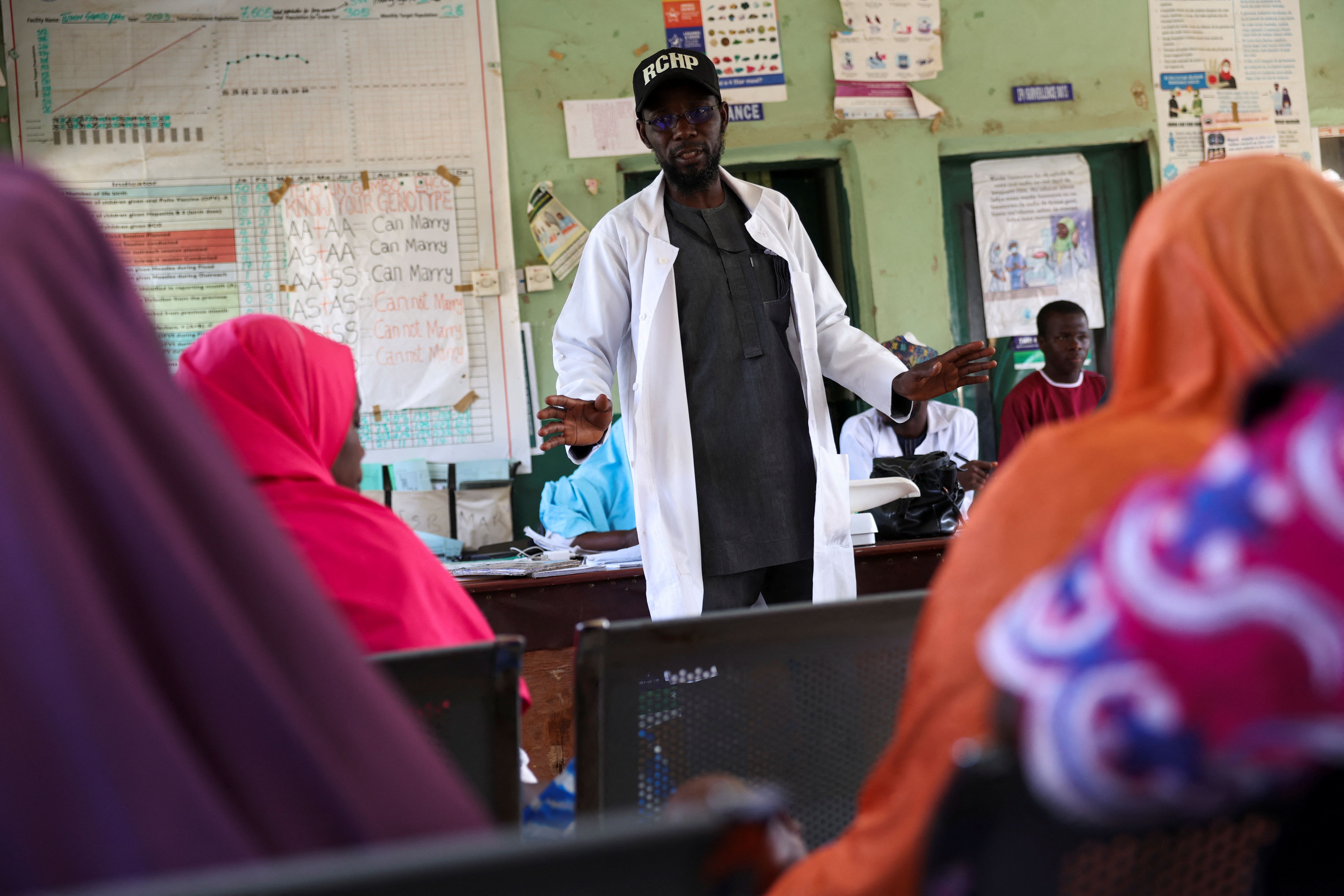 Responsável por centro de atenção primária falando com mães que amamentam em Tudun Gambo, estado de Bauchi, na Nigéria, em 8 de maio de 2025
