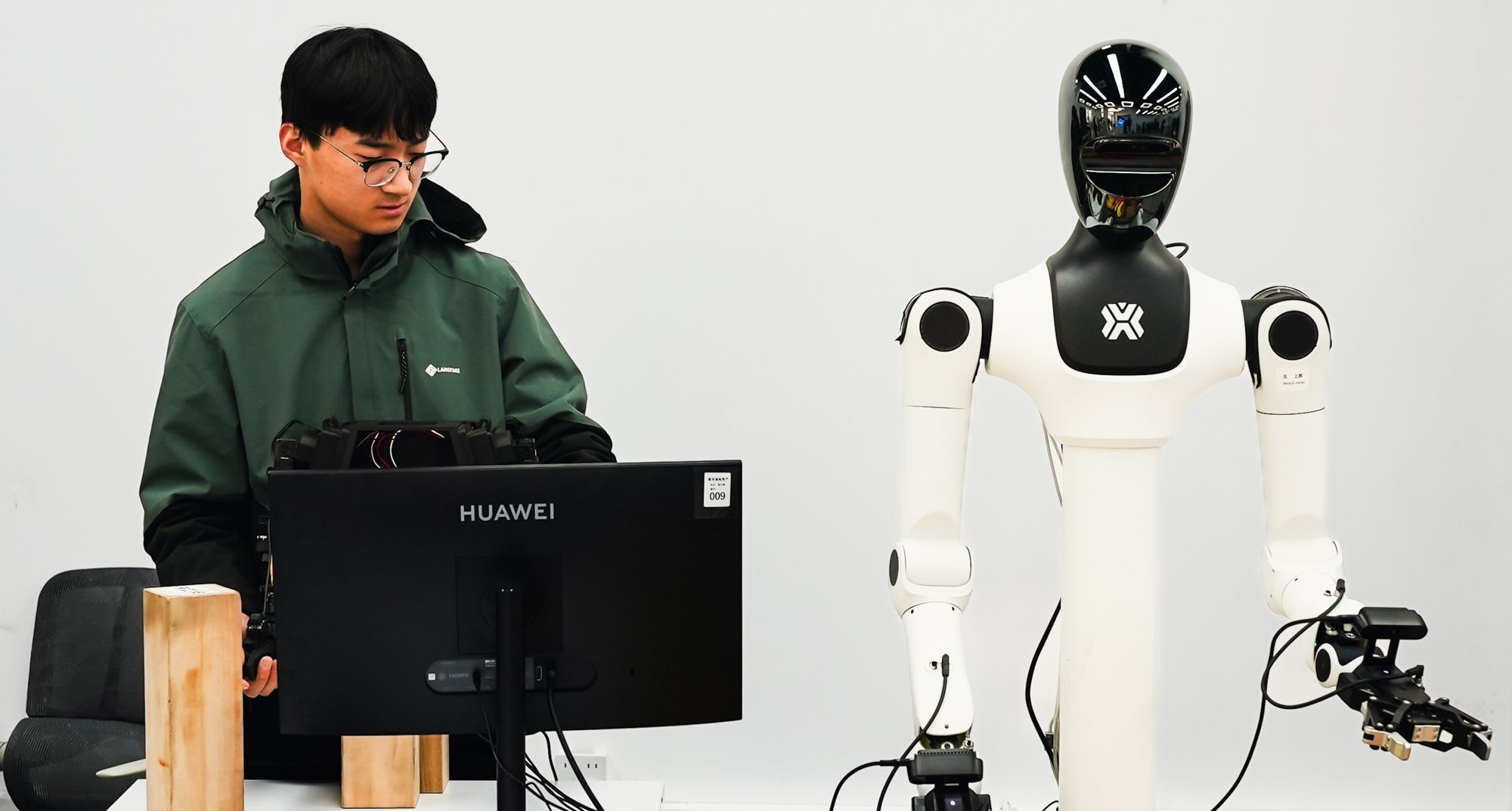 Trabalhadores são vistos treinando robôs humanoides. A foto foi tirada dentro do centro de treinamento de robôs da X-humanoid, nos arredores de Pequim, em 19 de março • Justin Robertson/CNN