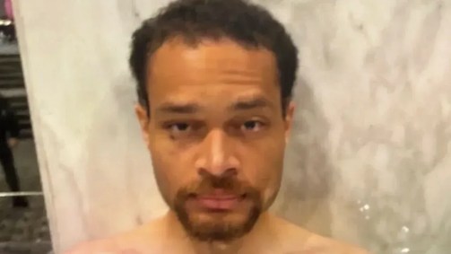 Foto obtida pela CNN mostra Cole Tomas Allen com cobertor térmico após ser detido no sábado, 25 de abril de 2026, no Washington Hilton, após ataque no jantar de correspondentes da Casa Branca
