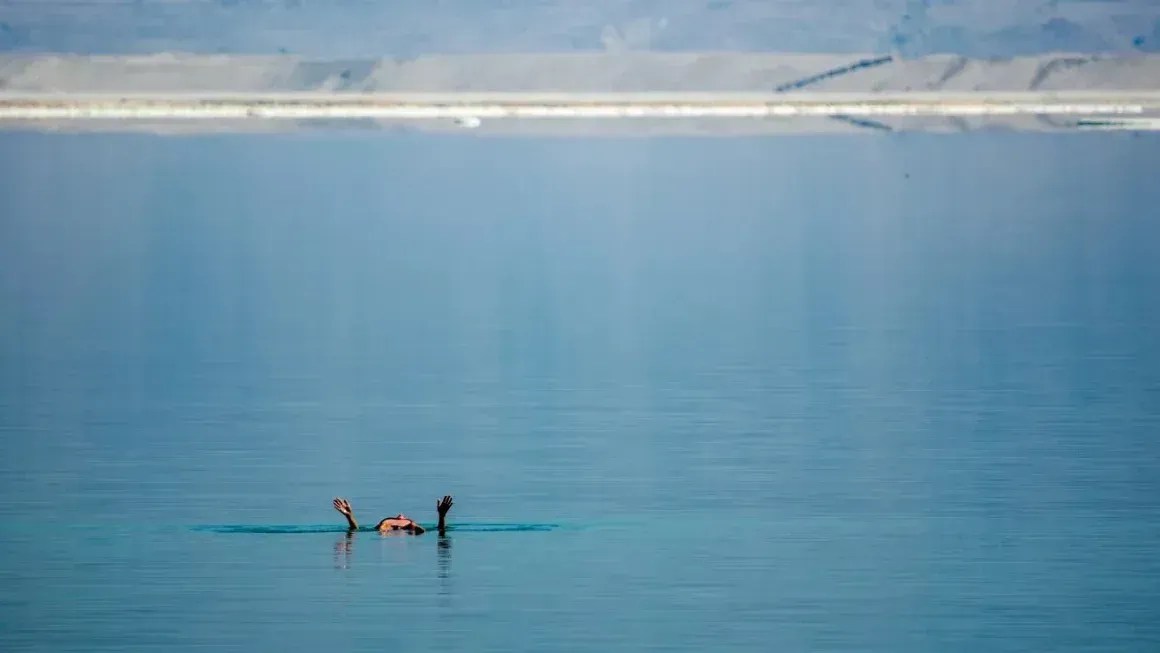 Um visitante do resort na Zona Desmilitarizada (DMZ), no sul de Israel, flutua nas lagoas de evaporação do Mar Morto • Bill Weir/CNN