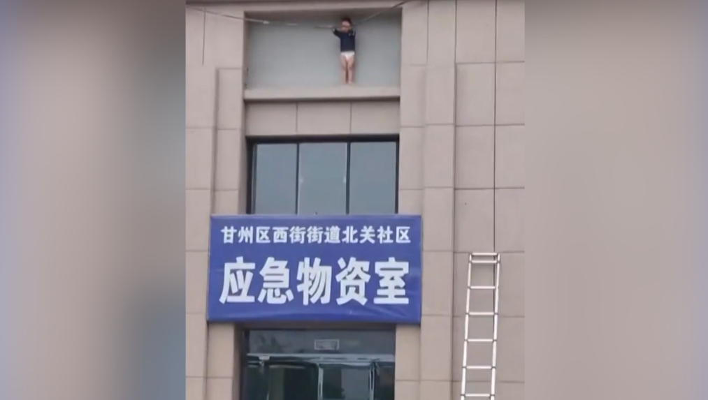 Momento em que uma criança de três anos é resgatada em área externa de prédio a 10 metros de altura na China