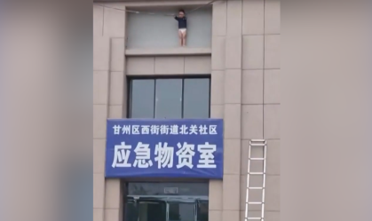 Momento em que uma criança de três anos é resgatada em área externa de prédio a 10 metros de altura na China