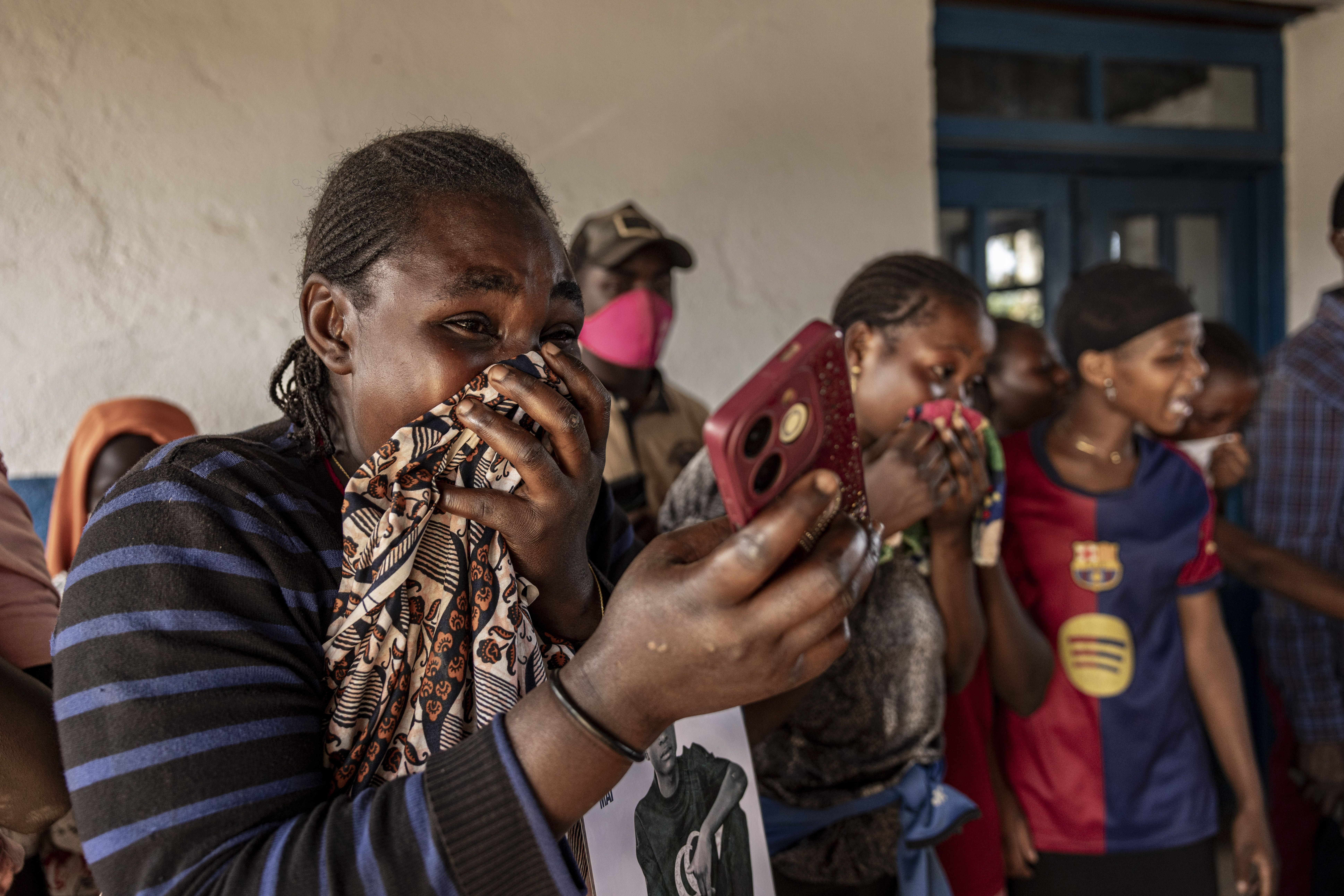 Pessoas lamentam enquanto trabalhadores se preparam para remover o corpo de alguém que se acredita ter morrido de Ebola no Hospital Geral de Mongbwalu, durante a resposta ao surto de Ebola em Mongbwalu, província de Ituri, leste da República Democrática do Congo, em 20 de maio de 2026. • Michel Lunanga/Getty Images