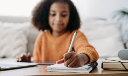 Girl with pen and notepad doing homework at home