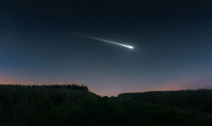 Meteoro ilumina o céu estrelado.