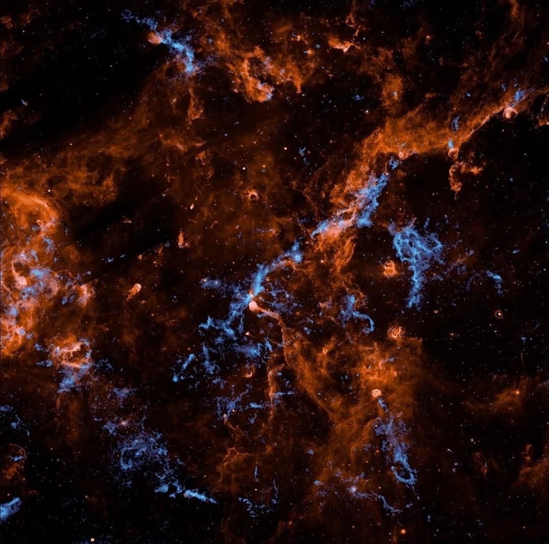 Nuvens azuis encontradas na Via Láctea podem armazenar gelo e outros componentes essenciais para vida no universo. • NASA/JPL-Caltech/IPAC/Hora et al.⁣