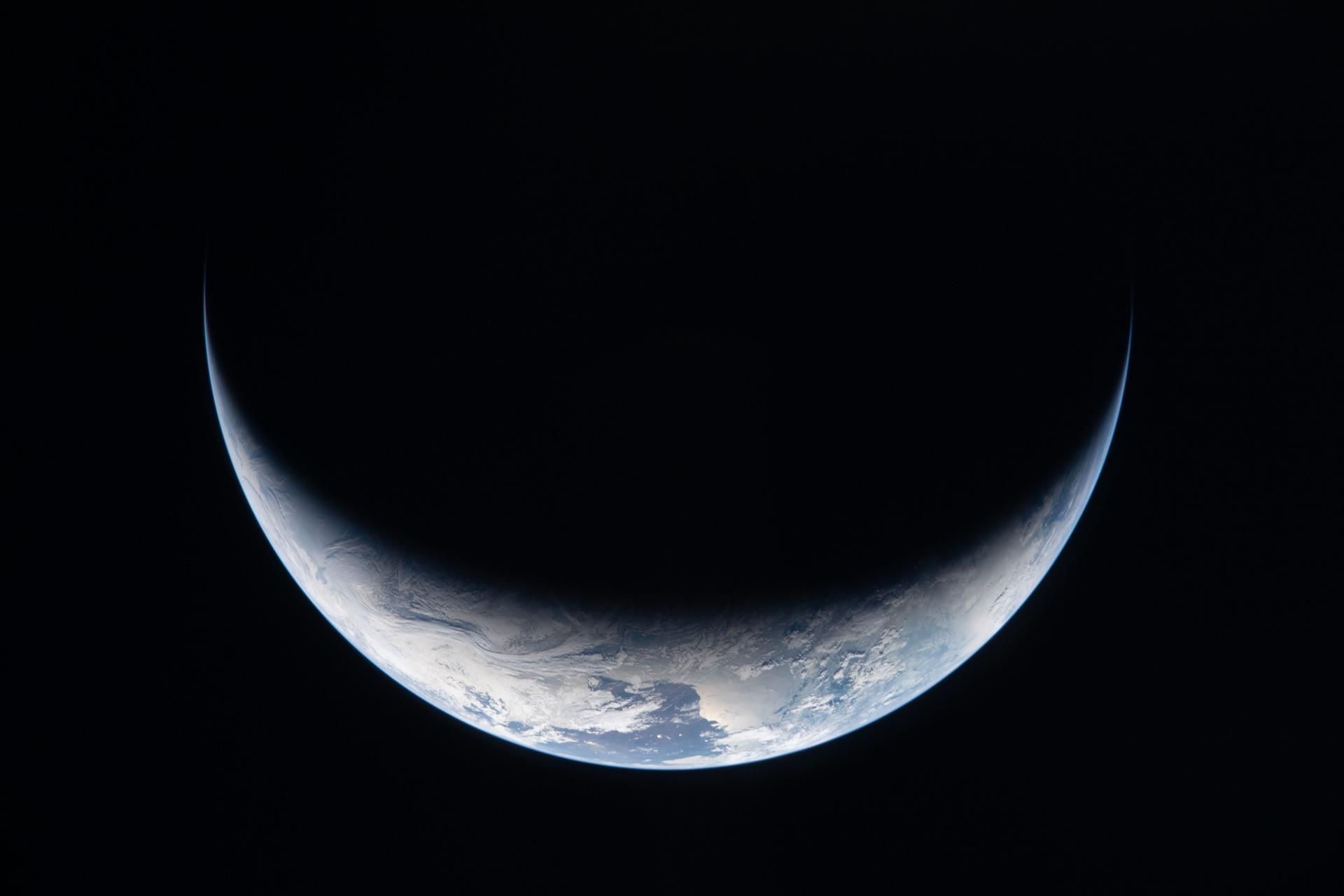 Nesta foto tirada por um membro da tripulação da Artemis II através de uma janela da espaçonave Orion, no terceiro dia da missão, uma pequena porção da Terra se destaca contra a escuridão do espaço. • Nasa