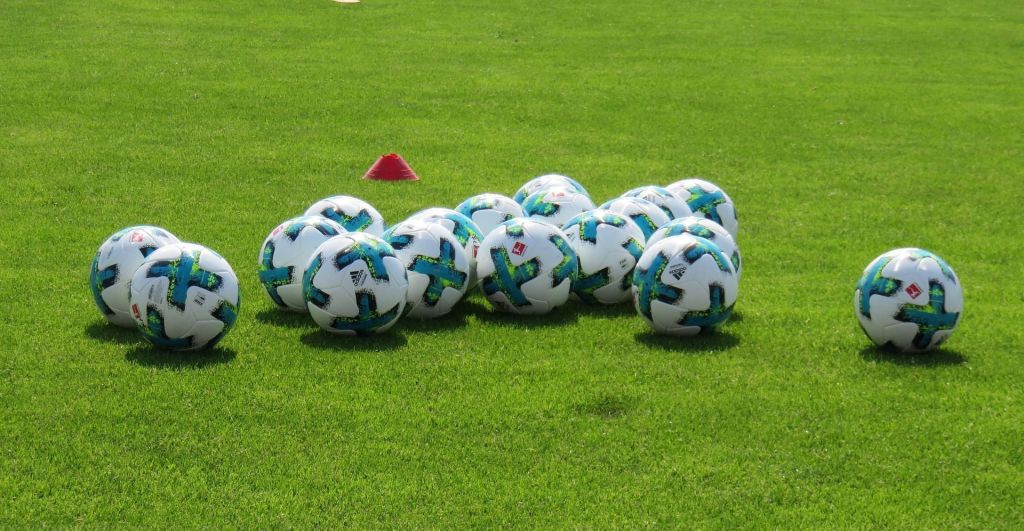 bolas-de-futebol-em-campo-verde-treino-esportivo-futebol-profissional