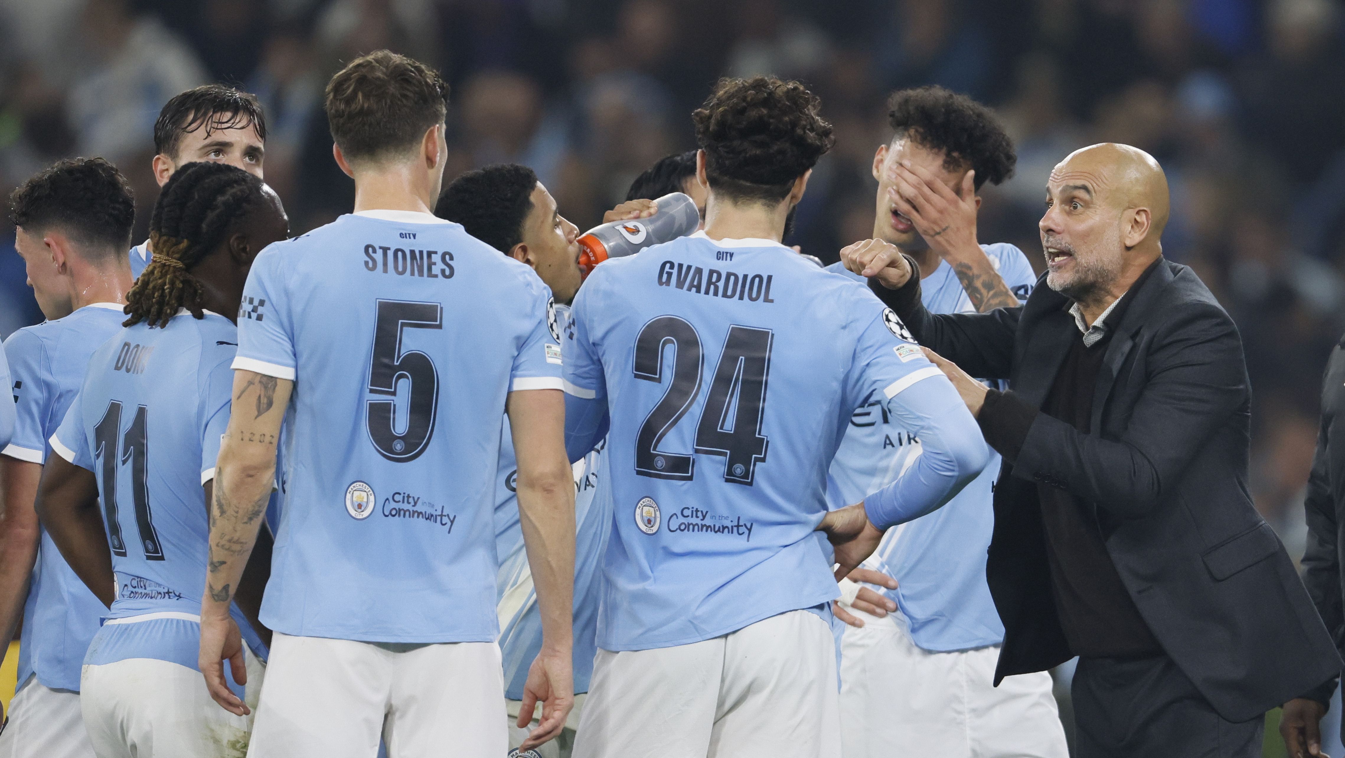 Guardiola conversa com os jogadores do Manchester City em jogo da equipe