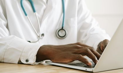 Médico mexendo no computador