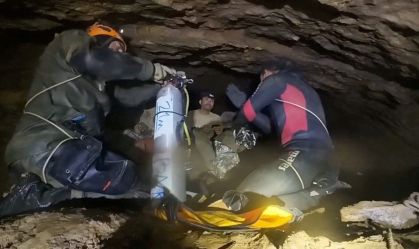 Nesta imagem capturada de um vídeo publicado em uma rede social no dia 30 de maio, mergulhadores de uma equipe internacional de resgate mostram aos moradores presos como usar o equipamento de mergulho na província de Xaisomboun, no Laos.
