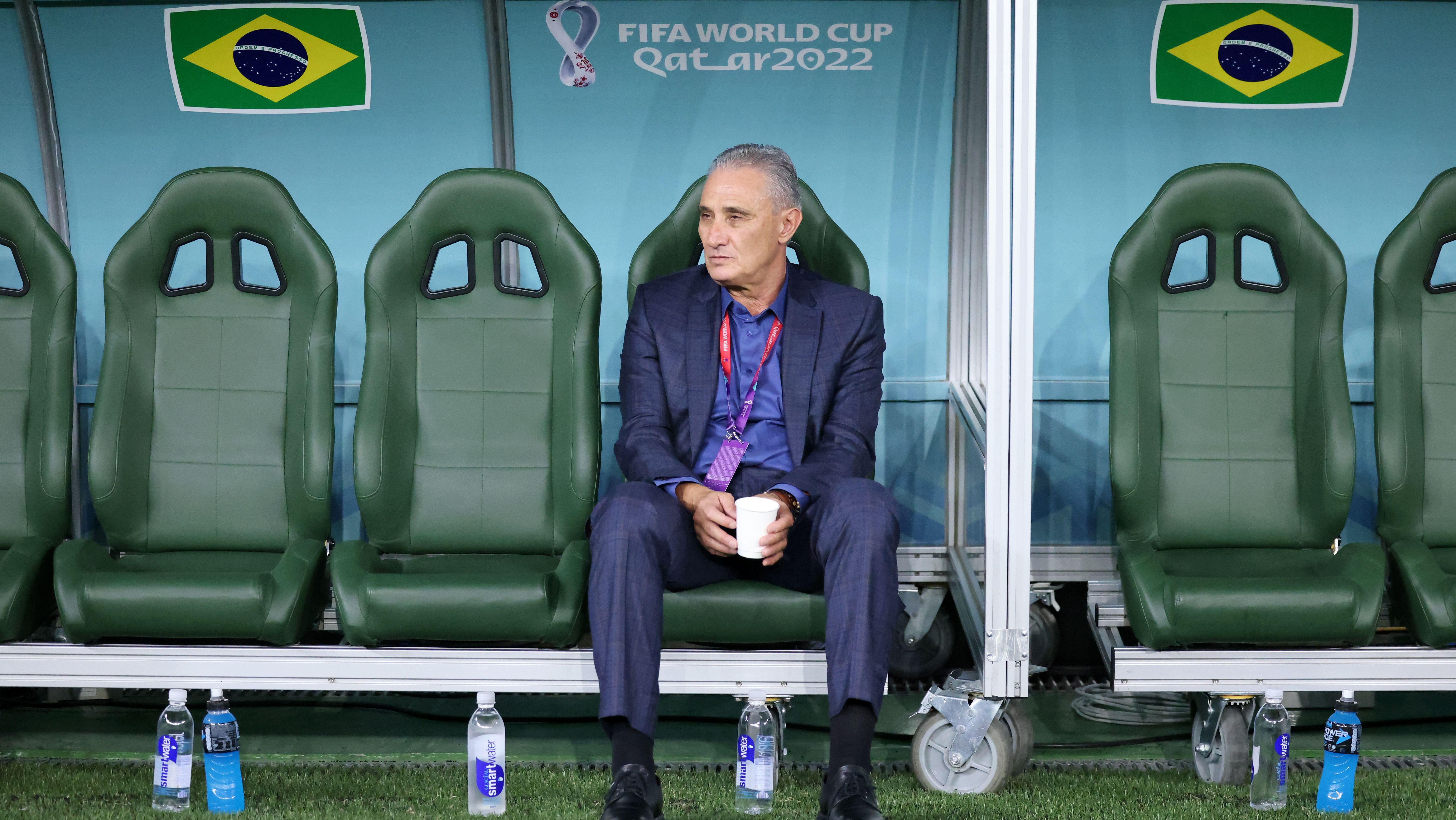 Técnico Tite sentado no banco de reservas do Brasil na Copa de 2022