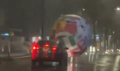 Momento em que uma bola inflável gigante rola pelas ruas de El Salvador