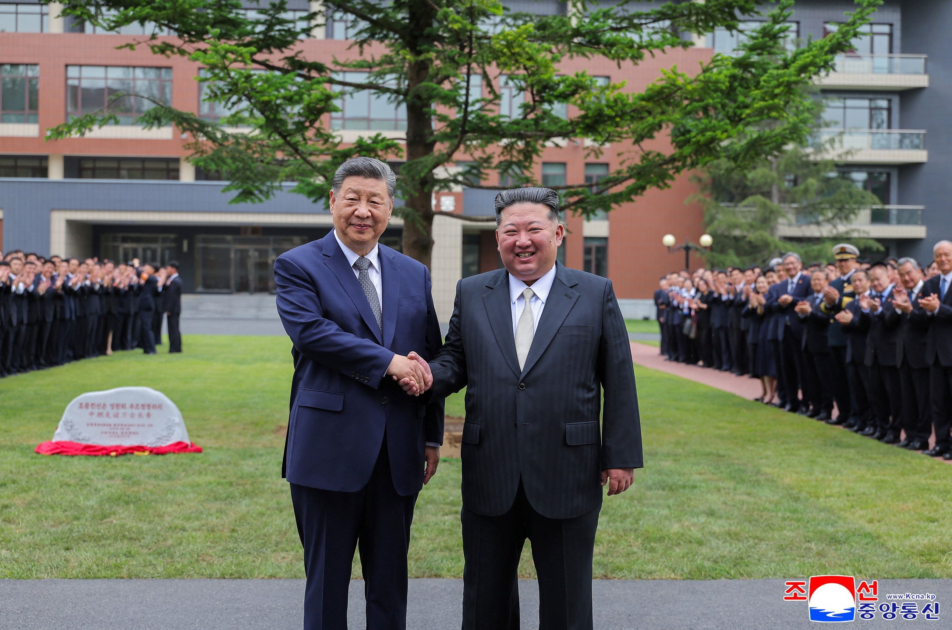 O presidente chinês, Xi Jinping, e o líder norte-coreano, Kim Jong-un, posam para foto enquanto visitam escola em Pyongyang nesta terça-feira (9)