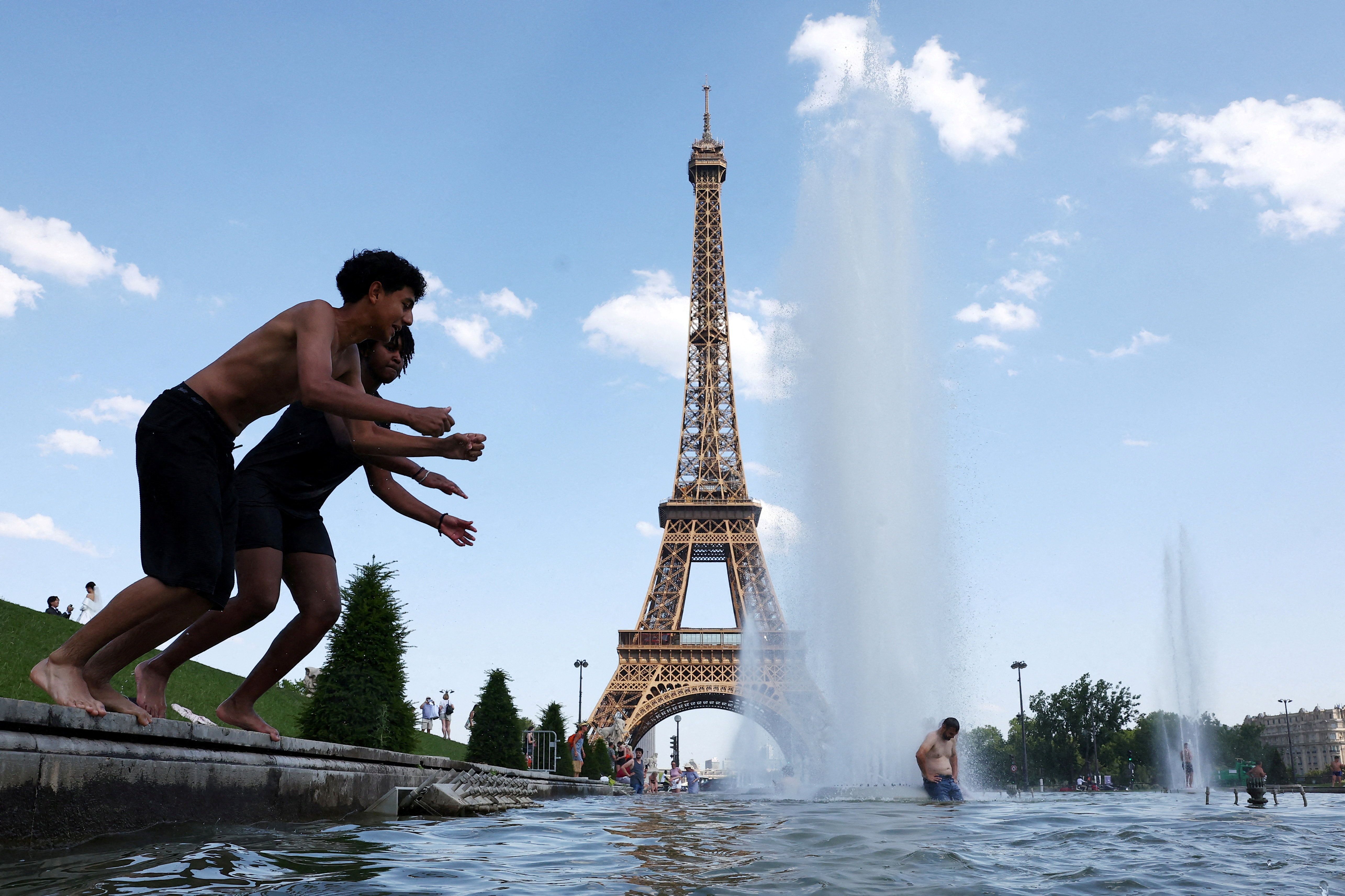 Pessoas se refrescam na Fonte do Trocadéro, ao lado da Torre Eiffel, em Paris