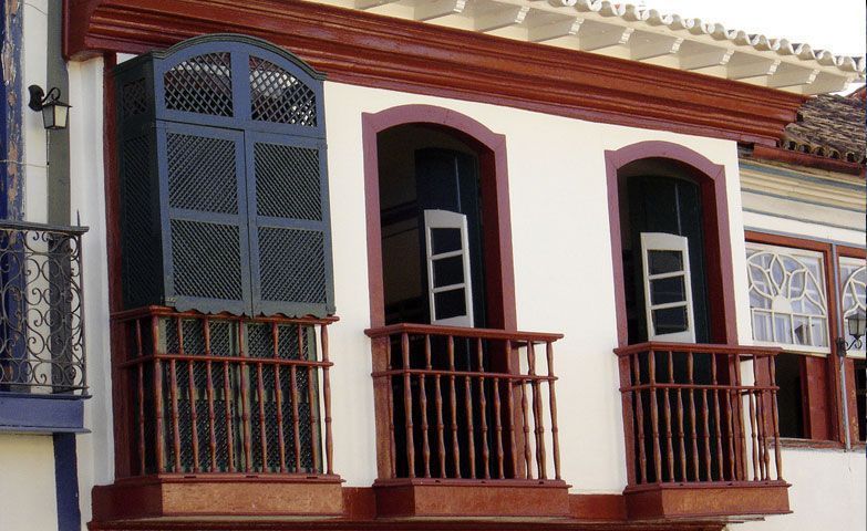 Fachada de casarão histórico em Diamantina, Minas Gerais, com destaque para a sacada protegida por um detalhado muxarabi de madeira. • IPHAN – Instituto do Patrimônio Histórico e Artístico Nacional