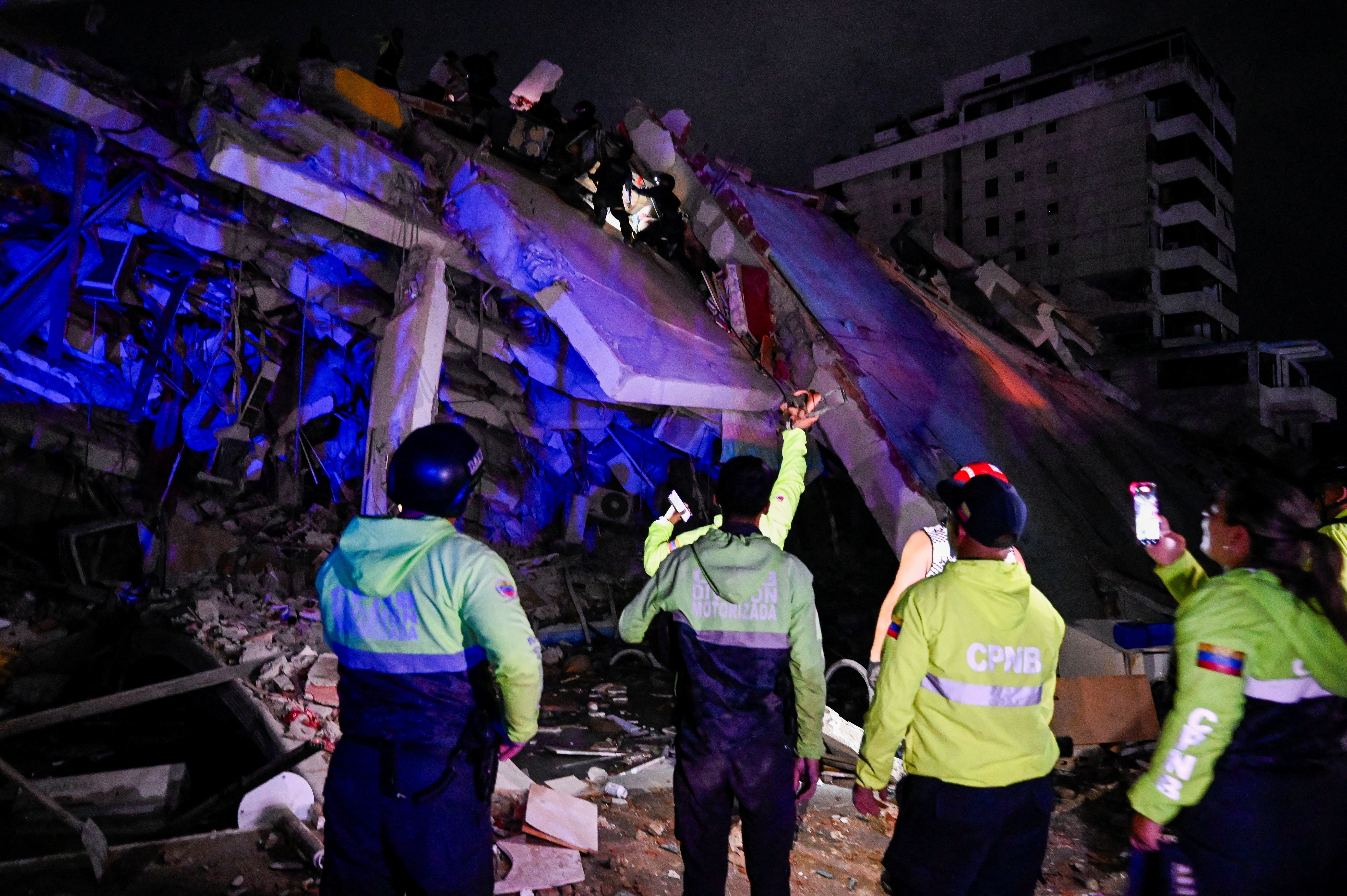 Equipes de emergência em um prédio danificado após um terremoto, em La Guaira