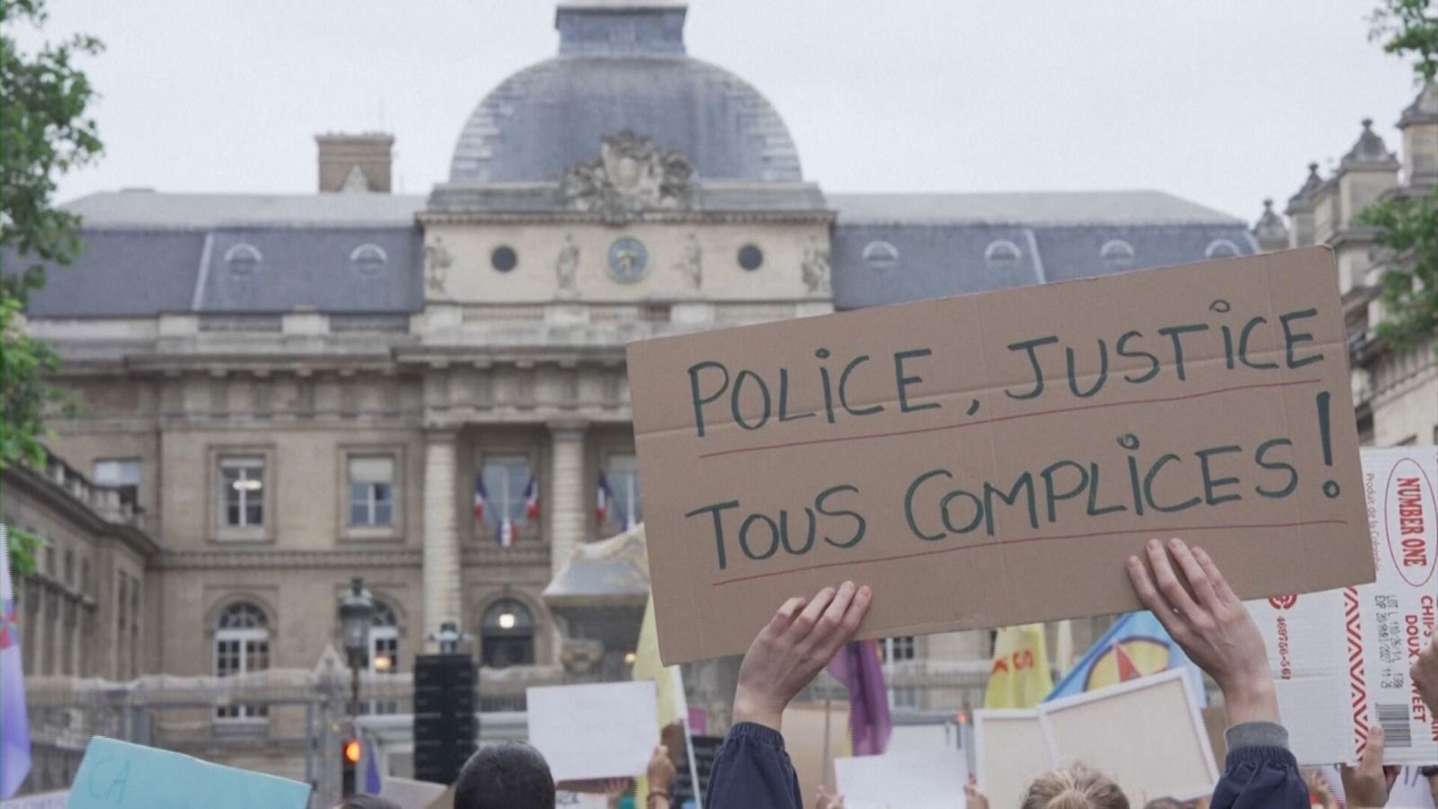 Placa com a frase: "Polícia, sistema judiciário, todos cúmplices" - durante protesto na França