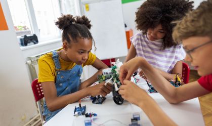 Children students building robotic cars at STEM class