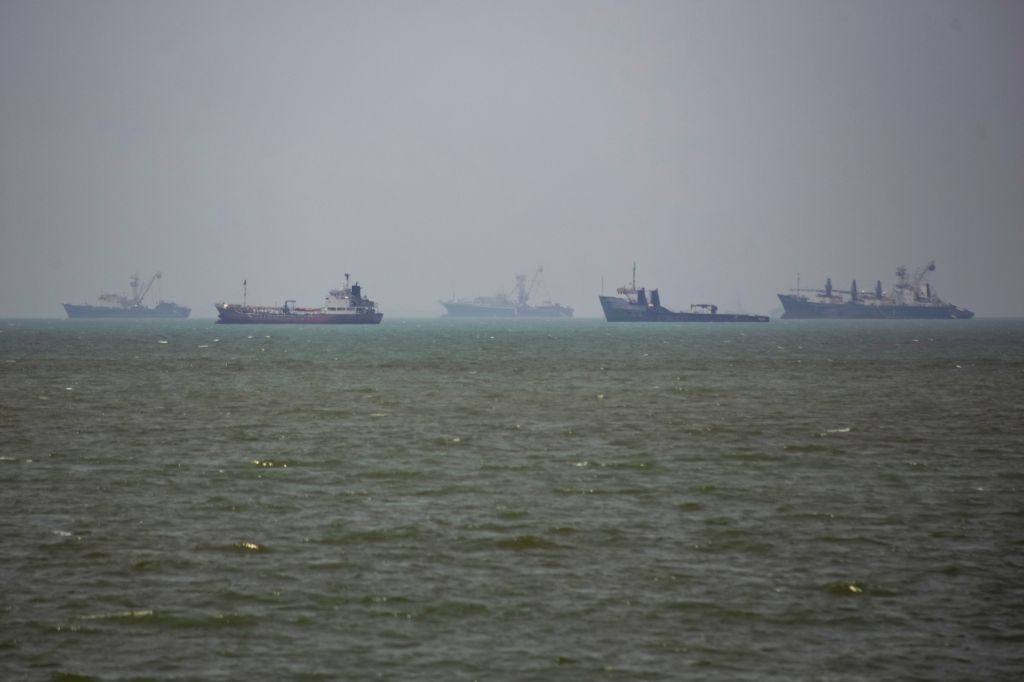 Grandes embarcações comerciais e um pequeno barco navegam pelas águas da cidade portuária de Bandar Abbas, no sul do Irã, no Estreito de Ormuz em 21 de junho de 2026