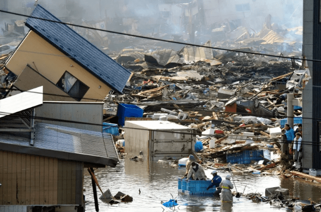 Pessoas que estavam em um contêiner flutuante são resgatadas de um prédio após o terremoto e tsunami na província de Miyagi, no nordeste do Japão • Kyodo/Reuters