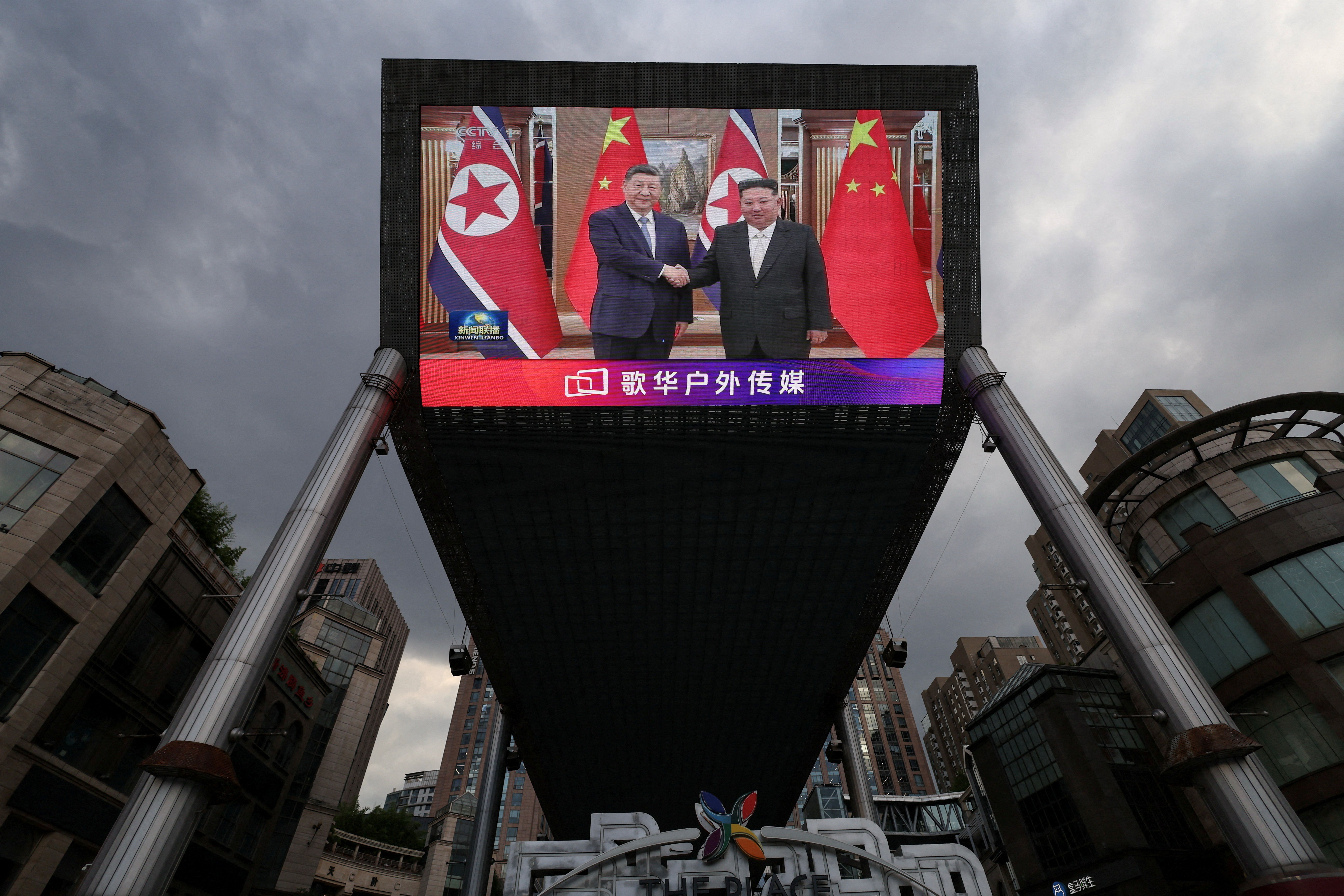 Tela gigante em uma área de compras em Pequim mostra imagens do presidente chinês, Xi Jinping, visitando a Coreia do Norte