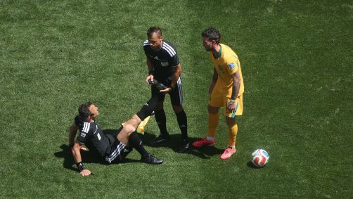 O árbitro Felix Zwayer com câimbras no duelo Estados Unidos x Austrália, pela Copa do Mundo