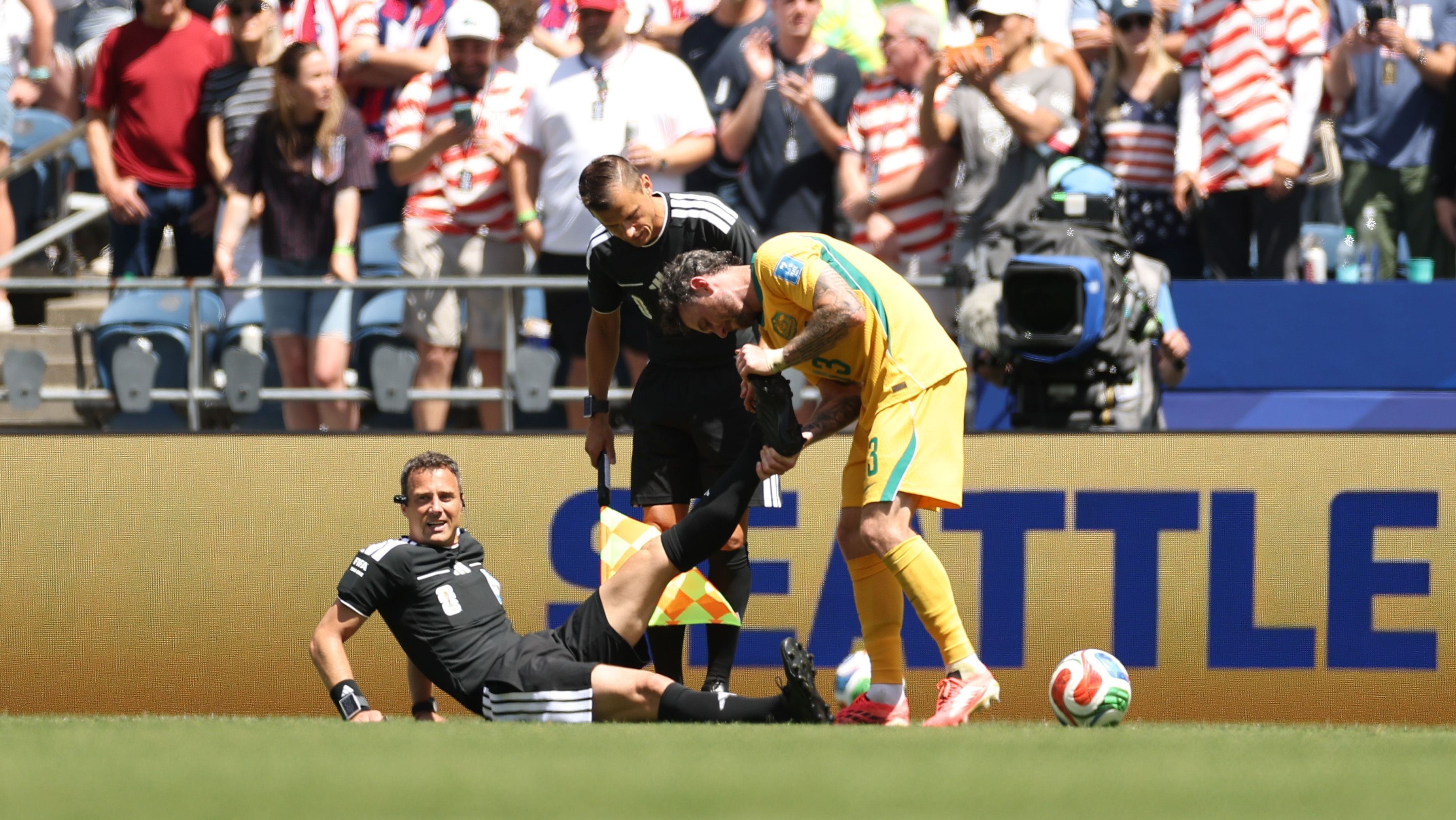 Felix Zwayer, árbitro do jogo entre Estados Unidos e Austrália, sendo atendido em campo • Sarah Stier - FIFA/FIFA via Getty Images