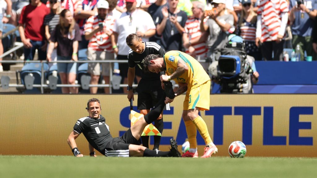 Felix Zwayer, árbitro do jogo entre Estados Unidos e Austrália, sendo atendido em campo