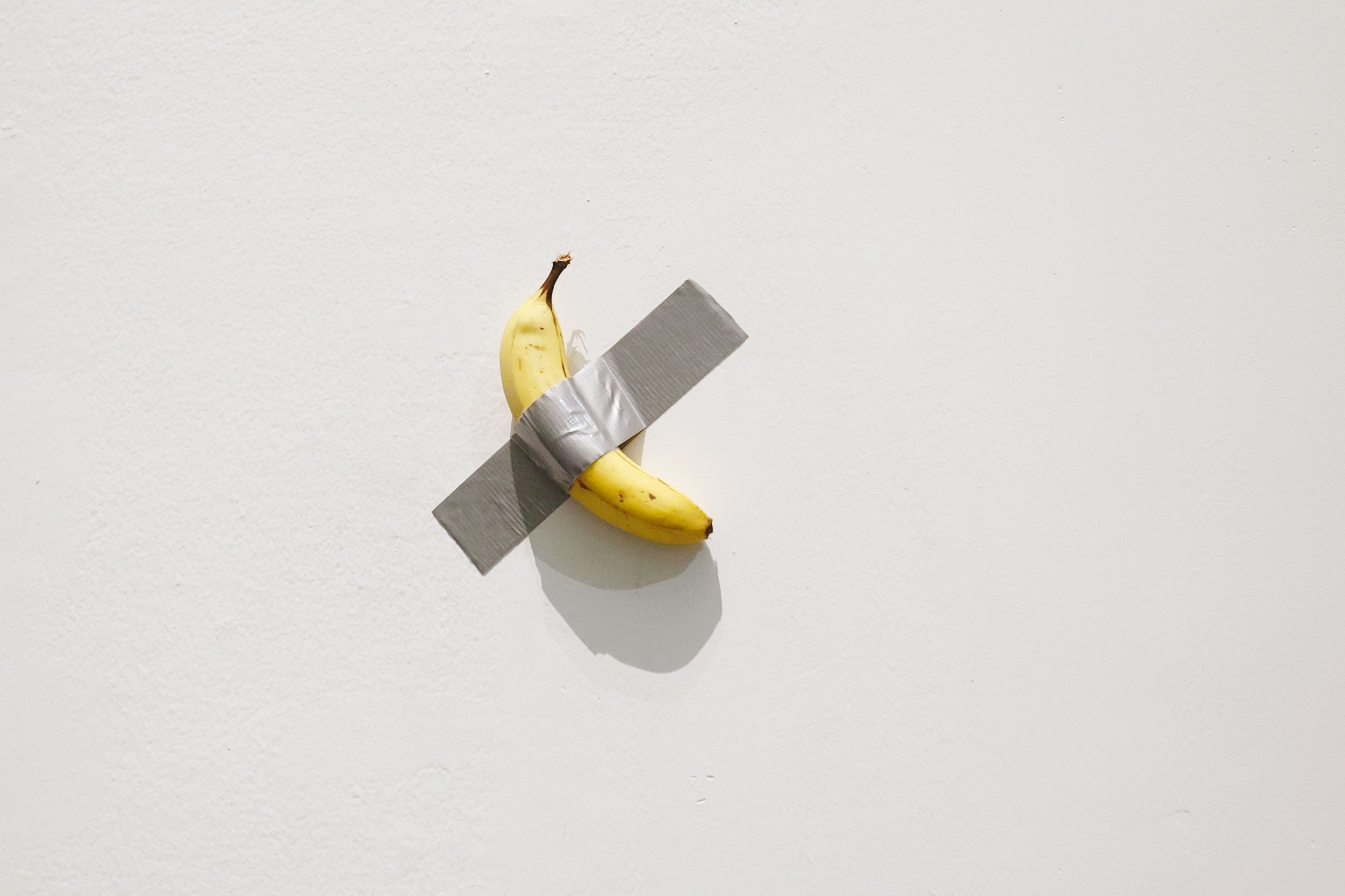 "Comedian" é uma obra de arte de Maurizio Cattelan afixada na parede de um museu com uma fita