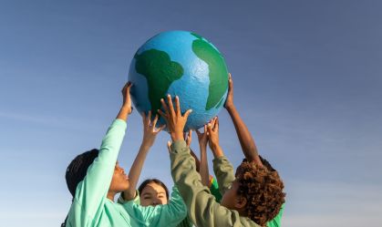 Group of children working together to hold up the world