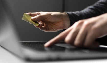 Homem usa dados do cartão no seu internet banking pelo notebook.