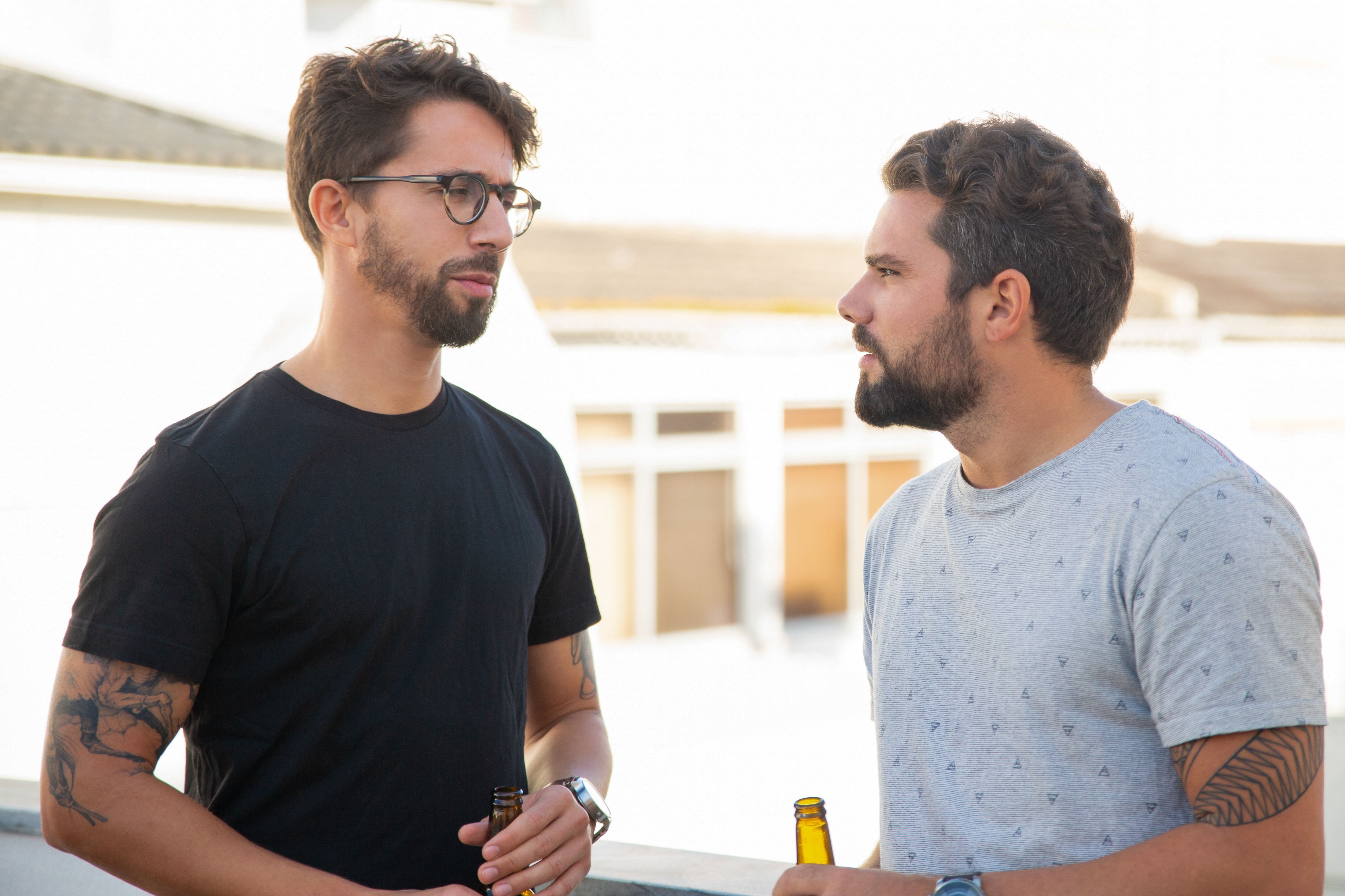 Best male friends discussing issues over bottle of beer