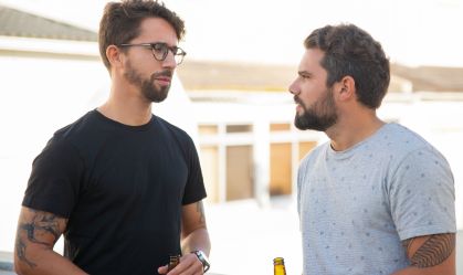 Best male friends discussing issues over bottle of beer