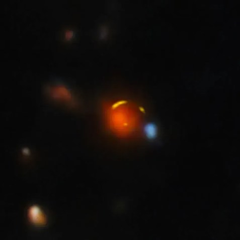 Červená galaxie v popředí láme světlo ze vzdálenější galaxie Shadow Blaster. • Mezinárodní observatoř Gemini/NOIRLab/NSF/AURA/ALMA (ESO/NAOJ/NRAO))
