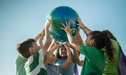 Children holding a planet outdoors