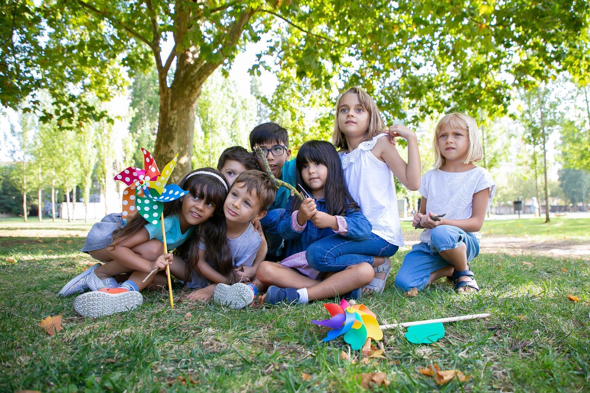 crian&ccedil;as-felizes-sentadas-juntas-na-grama-do-parque