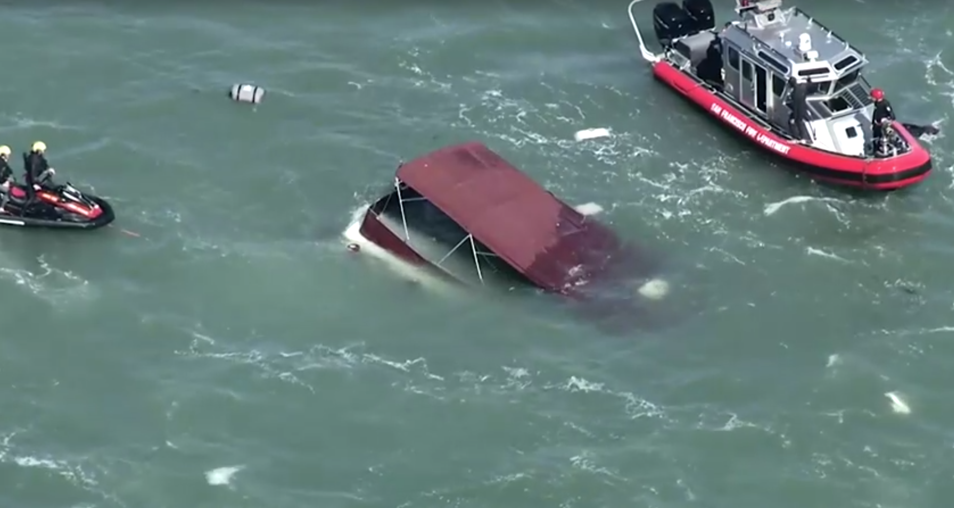 Imagens aéreas de equipes de resgate cercando a embarcação naufragada