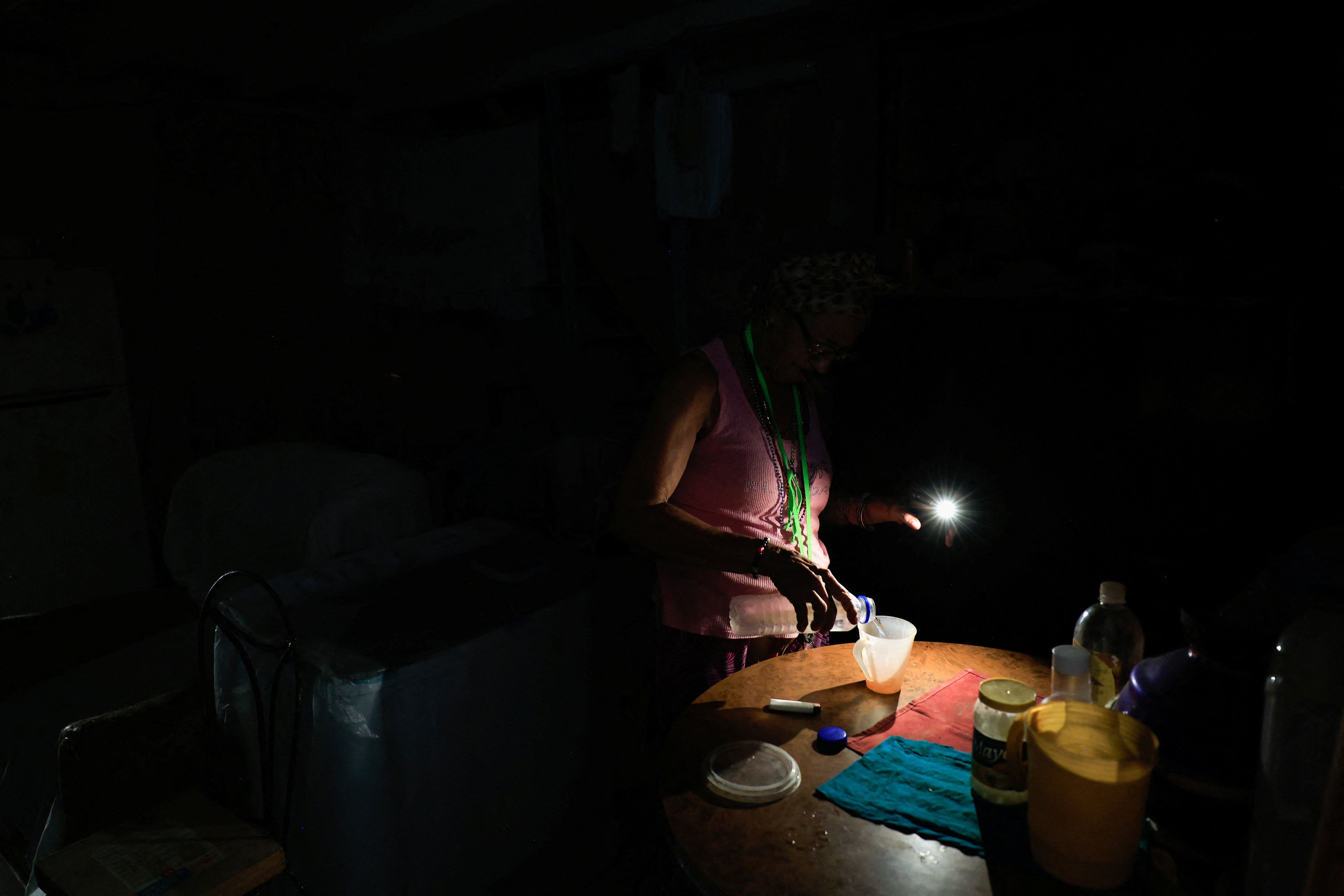 Pessoa sem energia em casa após um colapso de energia na rede elétrica de Cuba em 6 de julho