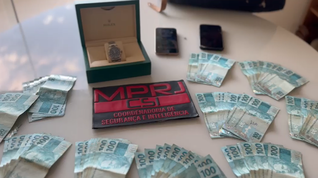 Durante a Operação Hidra de Lerna, agentes da CSI/MPRJ apreenderam celulares, relógio de luxo e dinheiro em espécie na casa de um dos investigados. • Reprodução - MPRJ