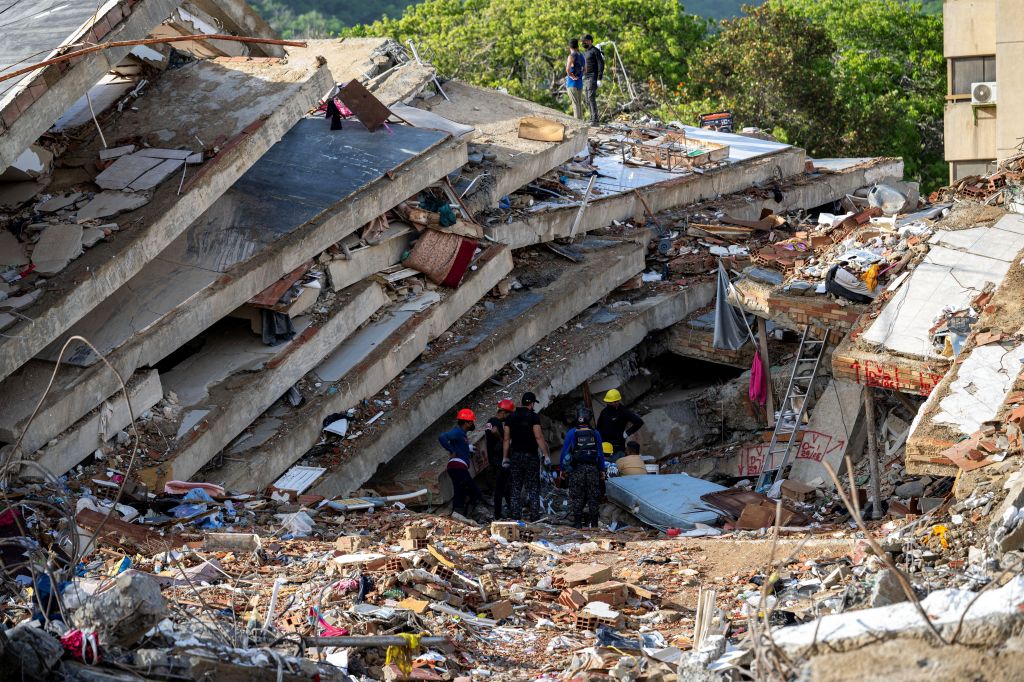 Equipes de resgate trabalham nos escombros para encontrar sobreviventes em um prédio desabado em Caraballeda, no Estado de La Guaira, na Venezuela