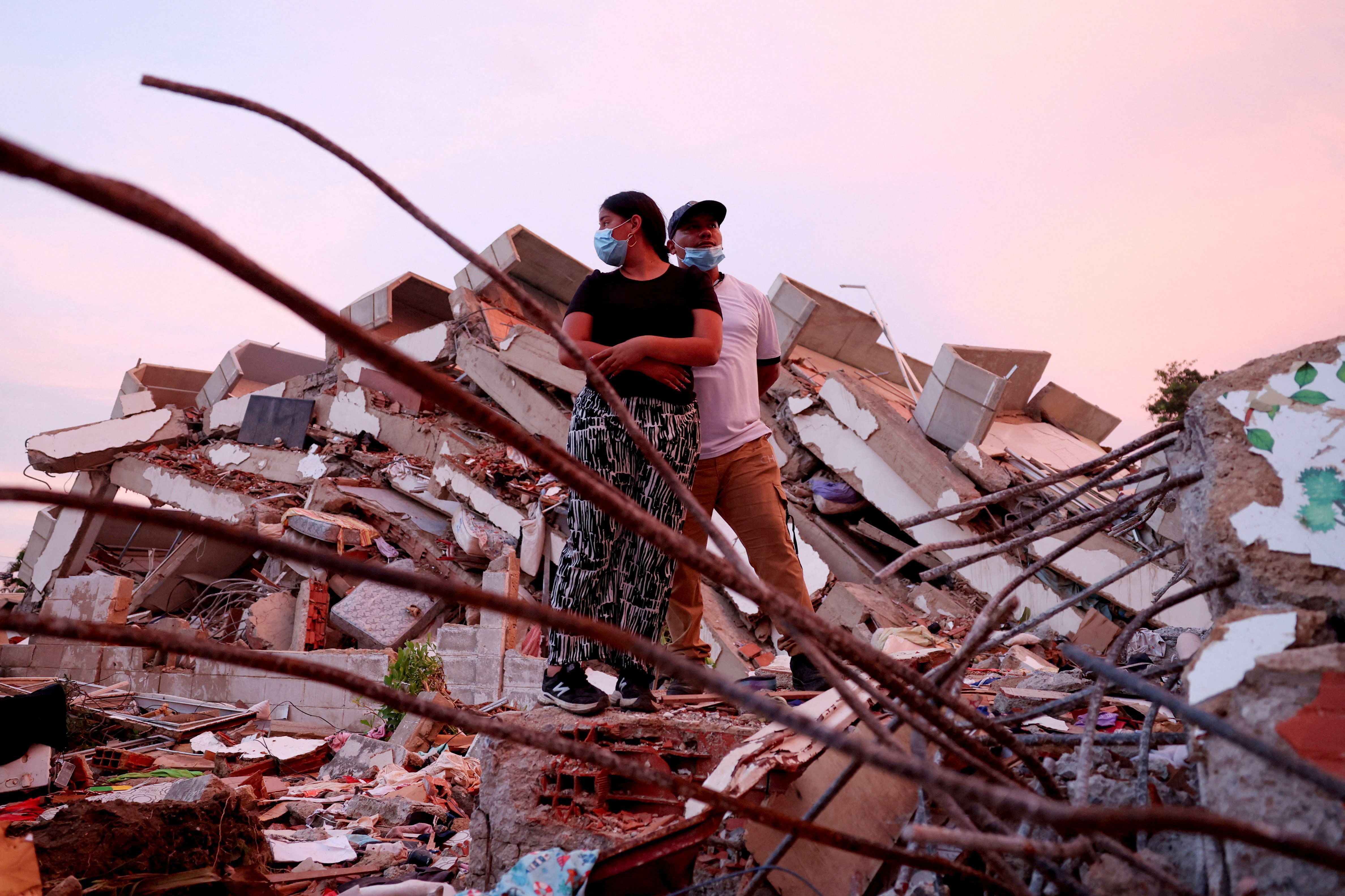 Casal está em meio aos escombros enquanto aguarda notícias das equipes de resgate que procuram seus filhos. 30 de junho de 2026 • REUTERS/Ricardo Arduengo